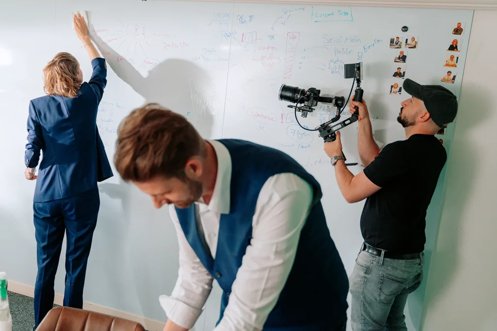 Regisseur beim Filmen eines Imagefilms vor einem Whiteboard.